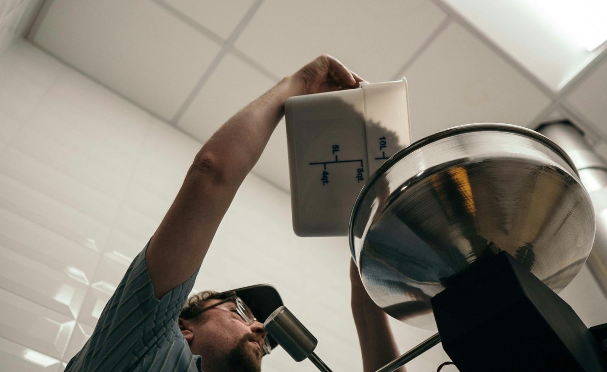 person pouring ingredient to mixer