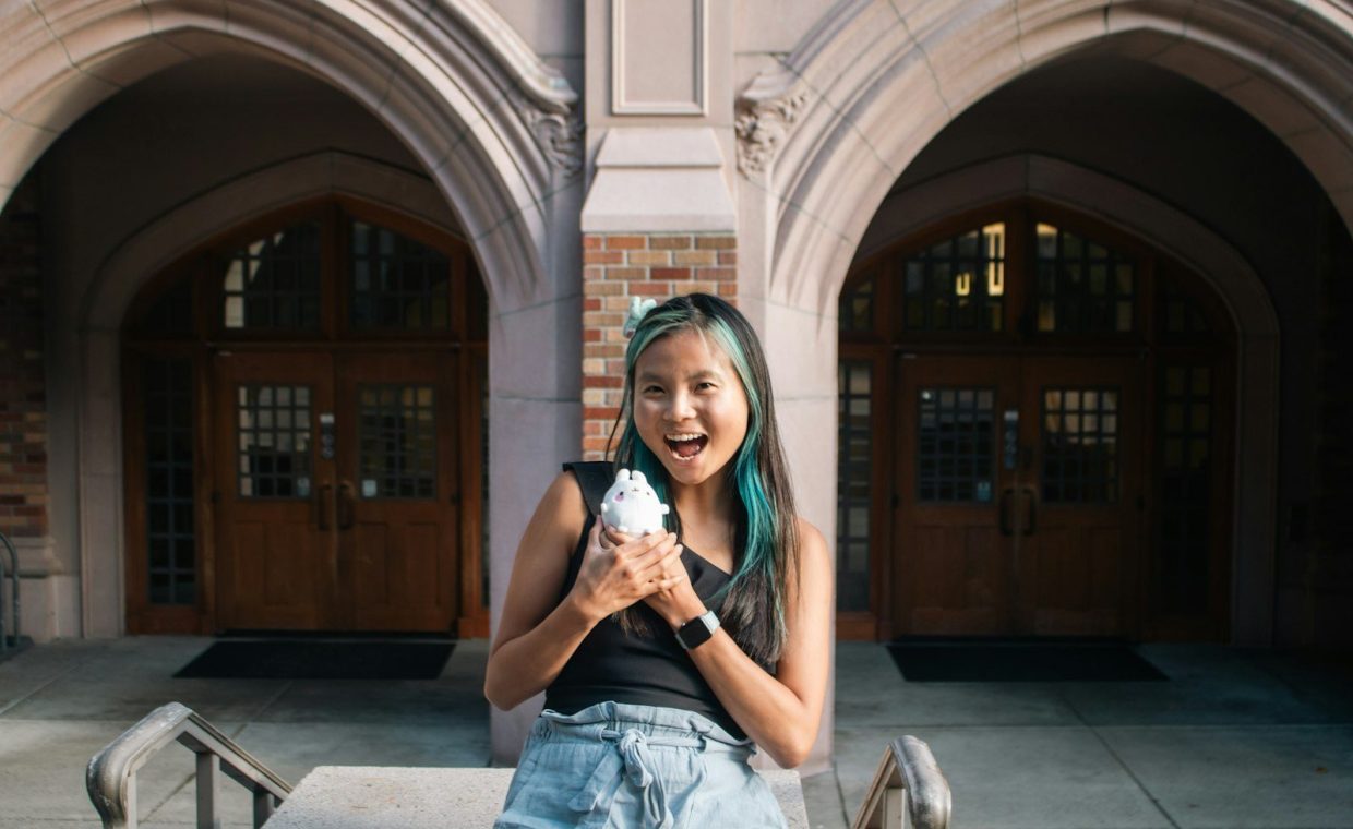 A girl sitting on a bench in front of a building