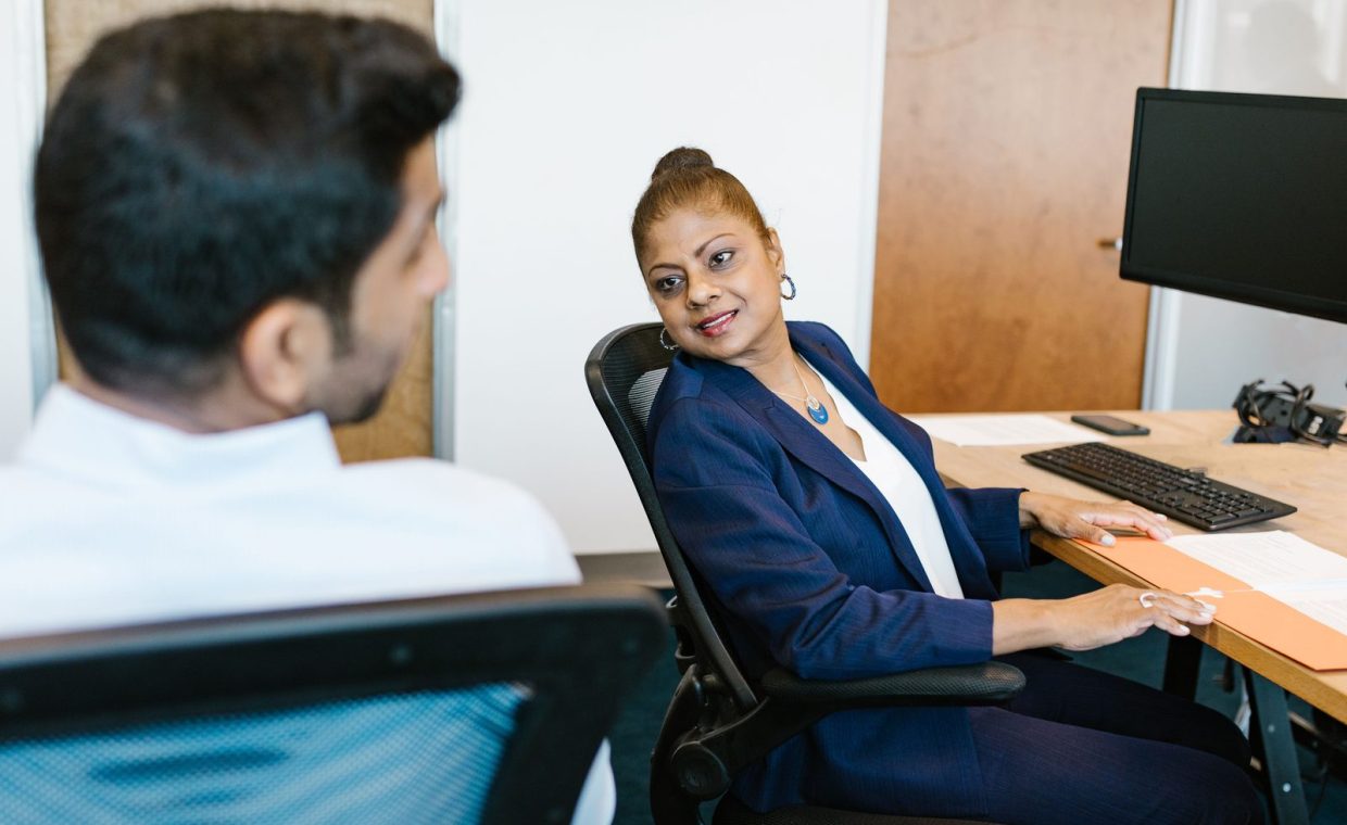 Two colleagues engaged in conversation, showcasing communication in a modern office.