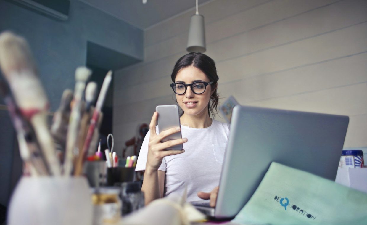 woman in white shirt using smartphone