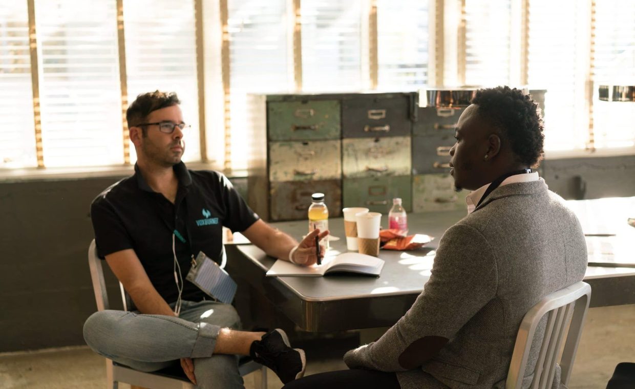 Two men having a focused business discussion in a sunlit office space.