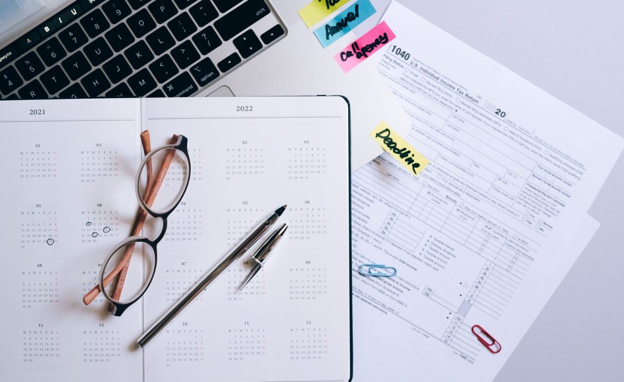 Organized workspace featuring a calendar, tax documents, and planner essentials.