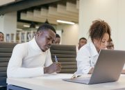 Diverse group of young professionals in a collaborative business meeting setting, actively participating.