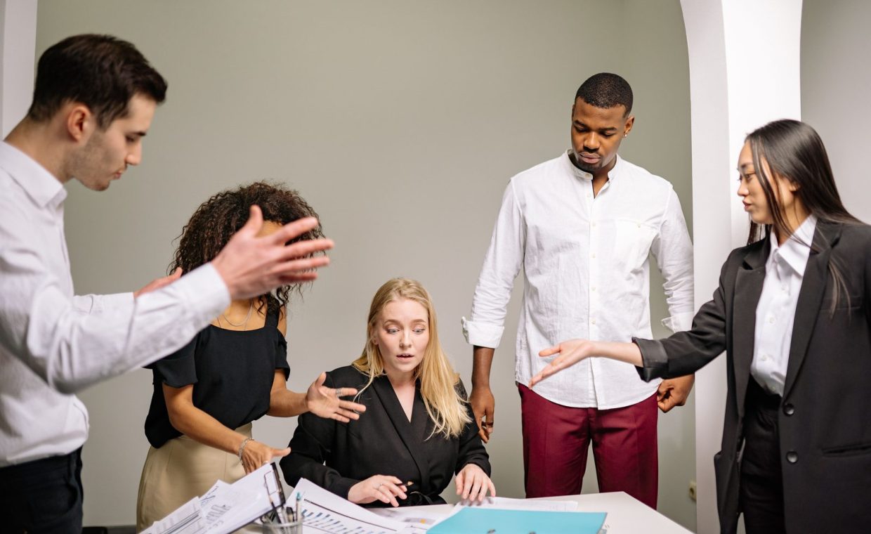 A diverse group of colleagues engaged in an intense discussion in an office setting.