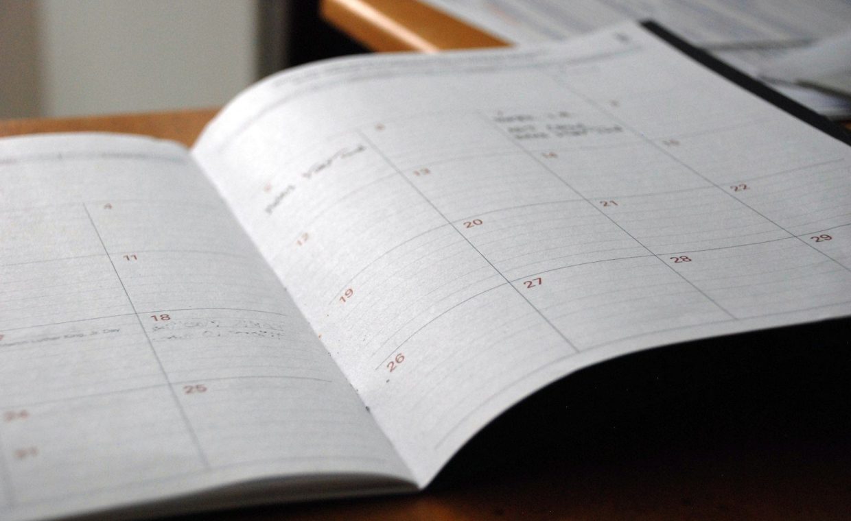 open monthly planner on wooden desk